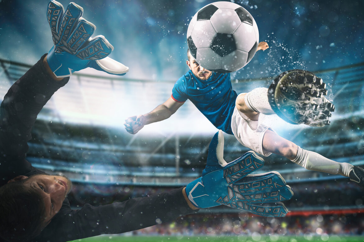 Soccer striker hits the ball with an acrobatic kick in the air at the stadium at night match